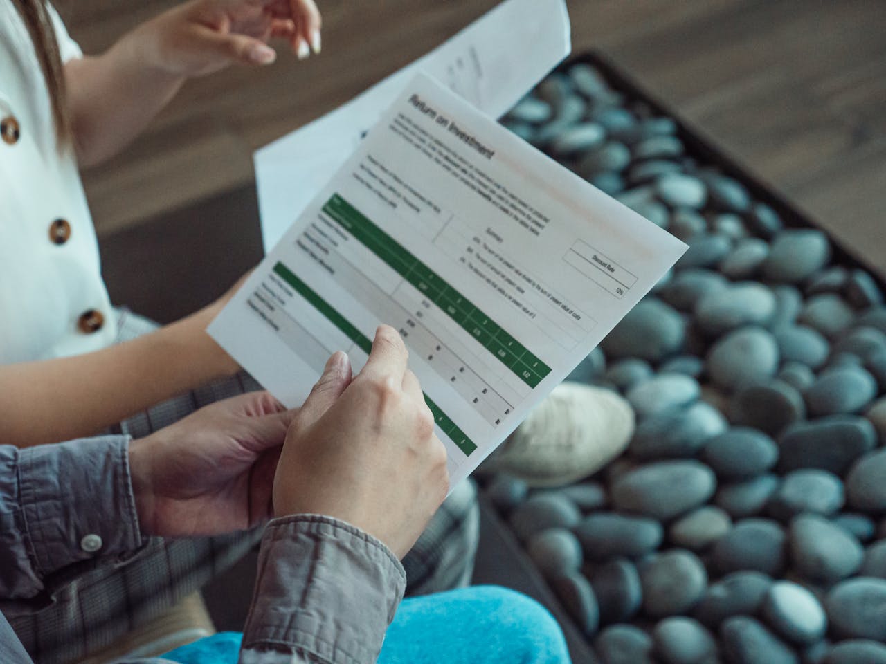 about-us-01 Two people discussing a financial document showing return on investment data.